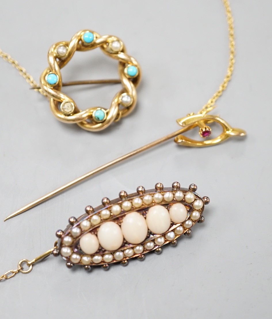 An Edwardian yellow metal, turquoise and split pearl set openwork brooch, 22mm, a similar coral and split pearl set ovoid brooch and a 15ct and gem set wish bone stick pin, gross weight 14.3 grams.